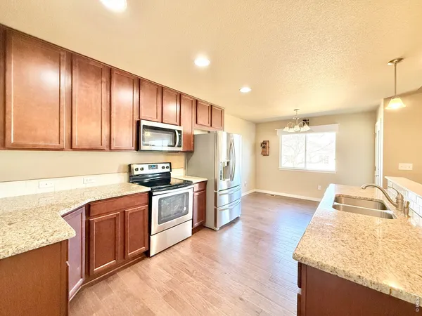 a kitchen with stainless steel appliances granite countertop wooden cabinets a stove a sink and dishwasher