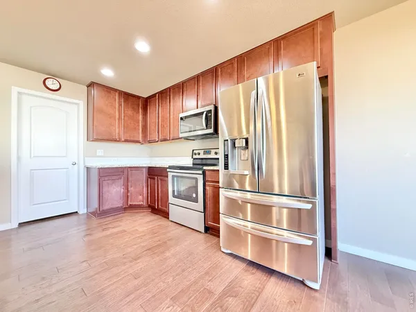 a kitchen with granite countertop stainless steel appliances and wooden cabinets