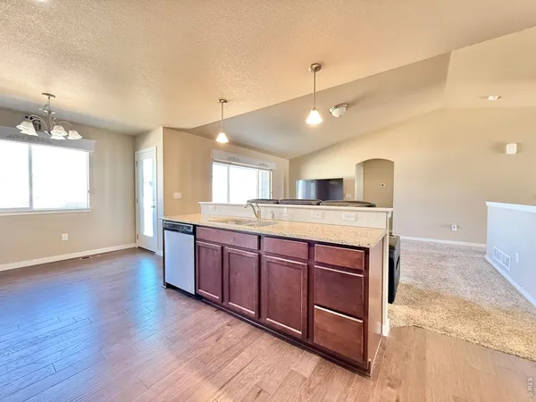 a large kitchen with stainless steel appliances granite countertop a large stove a sink dishwasher and a oven with wooden floor