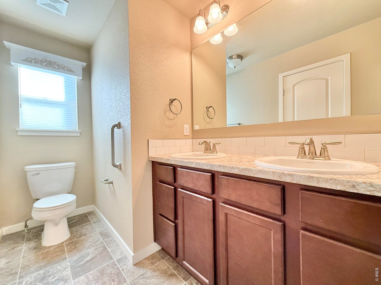 640 Cimarron Trail Ault, CO 80610 - Photo 9 of 15 a bathroom with a toilet sink and mirror
