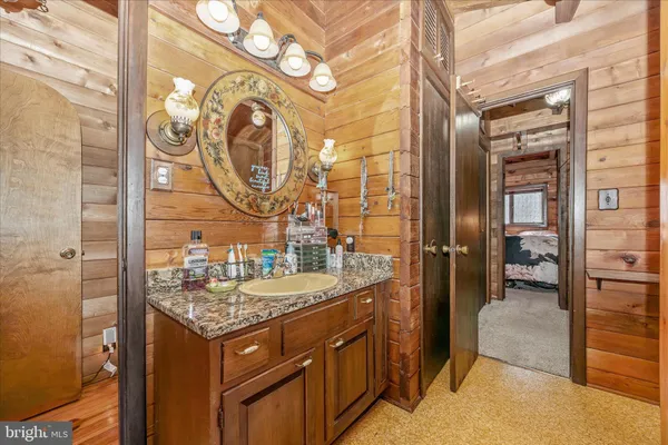 a bathroom with a granite countertop sink and a mirror