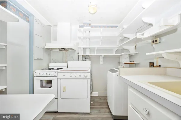 a view of a kitchen with cabinets appliances and wooden floor