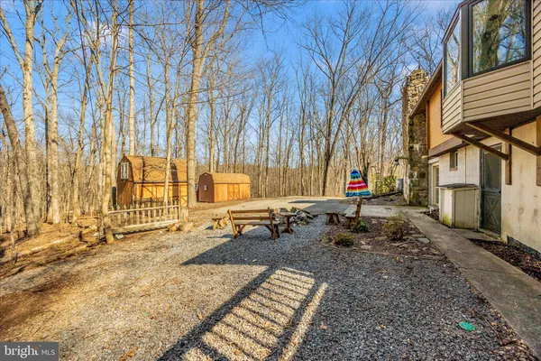 a backyard of a house with wooden fence and large trees
