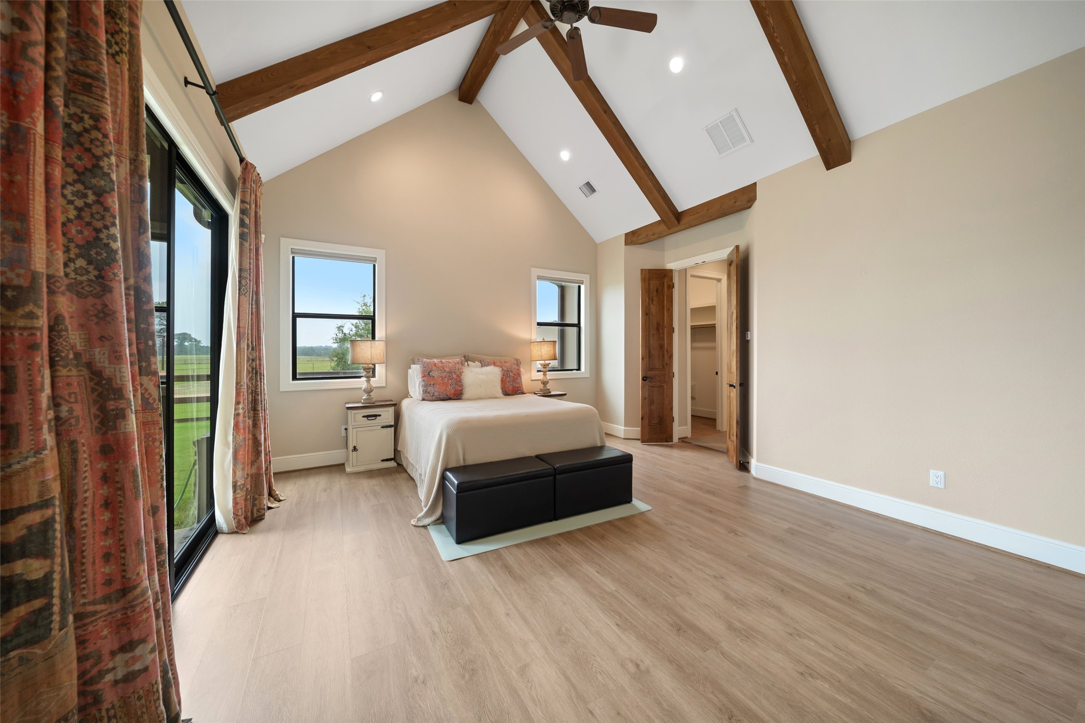 30163 High Spirit Ranch Road Hempstead, TX 77445 - Photo 23 of 49 a bedroom with a large bed and a chandelier