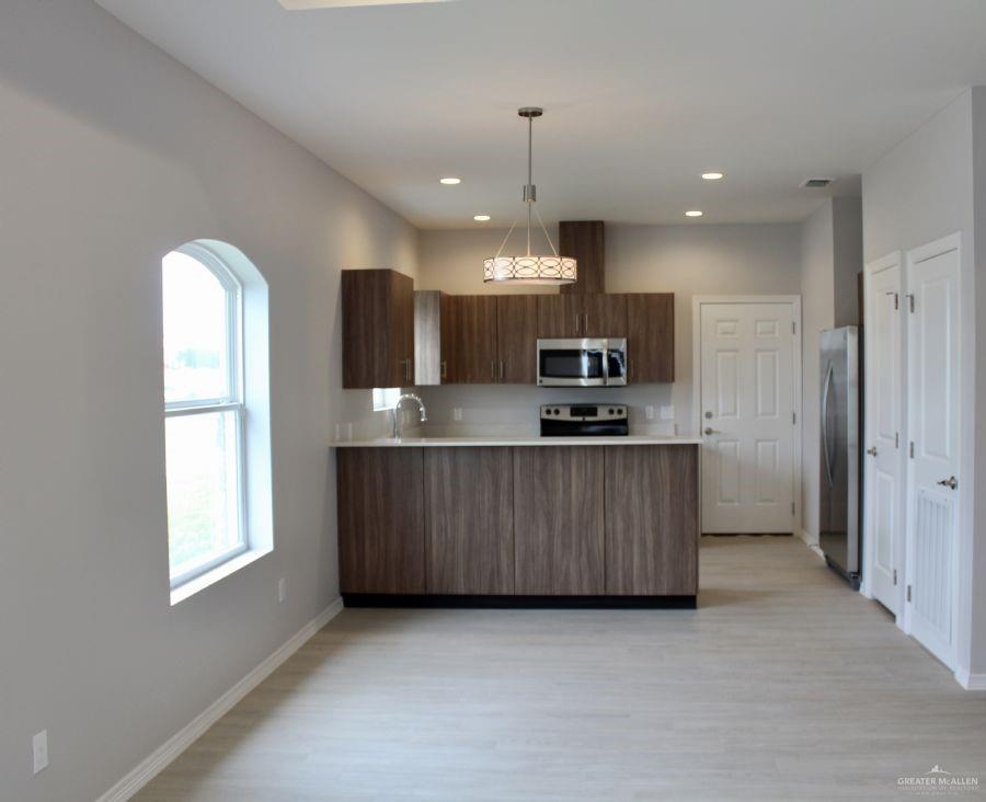 1901 Jackson Street, Unit 4 Weslaco, TX 78599 - Photo 5 of 10 a large kitchen with a large counter top stainless steel appliances and cabinets