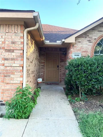 a couple of potted plants in front of door