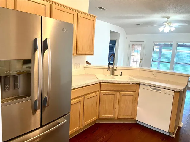 a kitchen with a refrigerator sink and cabinets