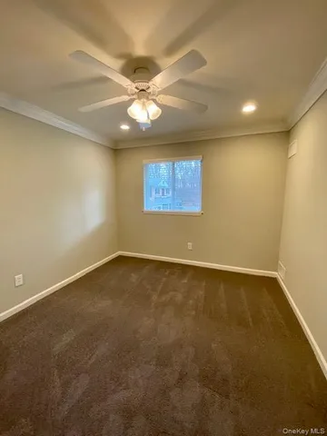an empty room with a ceiling fan and window