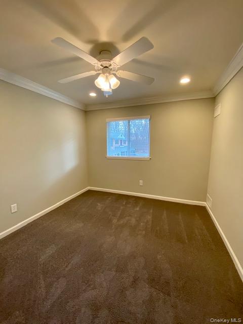 32 Country Club Drive, Unit 32C Coram, NY 11727 - Photo 6 of 8 an empty room with a ceiling fan and window