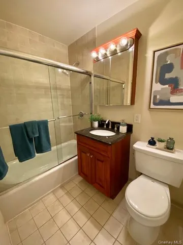 a bathroom with a granite countertop toilet sink and mirror