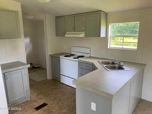 a kitchen that has a sink and a stove in it