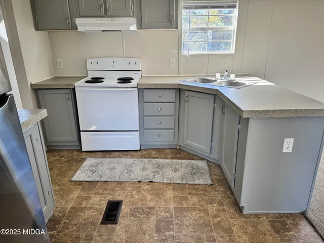 a kitchen with a sink stove and refrigerator