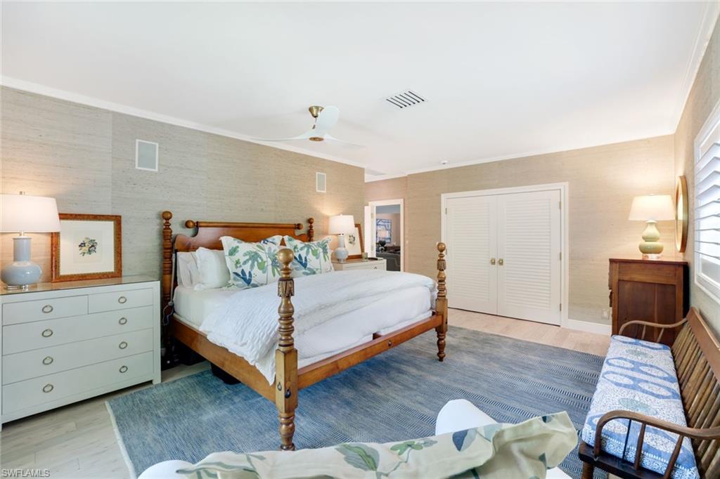 642 6th Avenue North Naples, FL 34102 - Photo 13 of 25 Bedroom with a closet, light wood-style floors, a ceiling fan, and crown molding