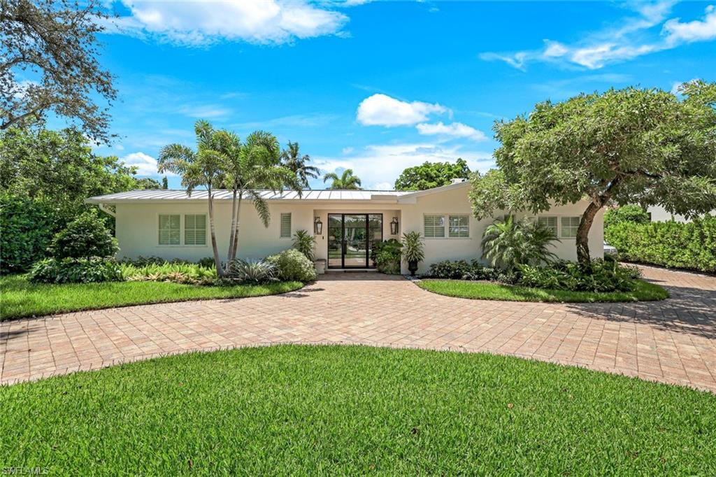 642 6th Avenue North Naples, FL 34102 - Photo 2 of 25 View of front of property featuring stucco siding and a front yard