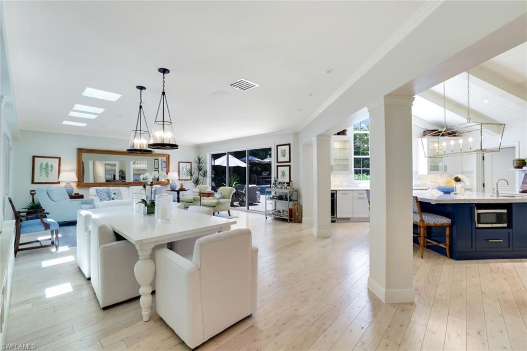 642 6th Avenue North Naples, FL 34102 - Photo 8 of 25 Dining room featuring a chandelier, light wood finished floors, ornamental molding, and beverage cooler