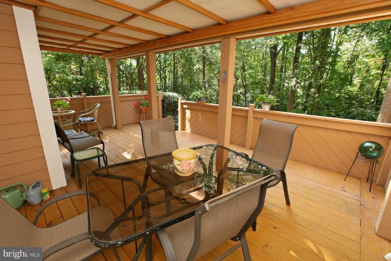 1521 Church Hill Place, Unit 1521 Reston, VA 20194 - Photo 14 of 20 a view of a patio with table and chairs and couches with wooden floor and fence