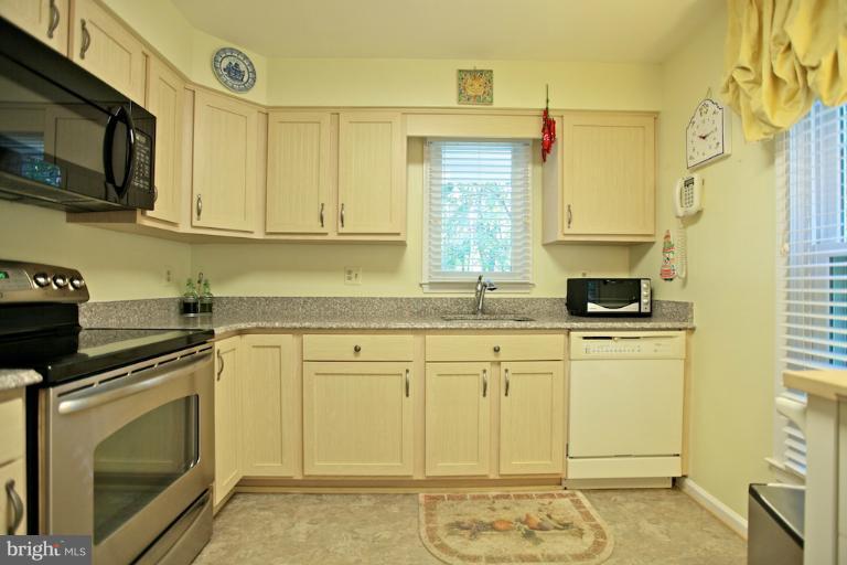 1521 Church Hill Place, Unit 1521 Reston, VA 20194 - Photo 16 of 20 a kitchen with stainless steel appliances granite countertop a stove a sink and a microwave