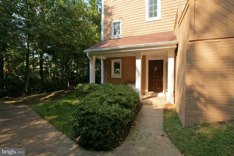 1521 Church Hill Place, Unit 1521 Reston, VA 20194 - Photo 20 of 20 a view of a house with brick walls and a yard with plants