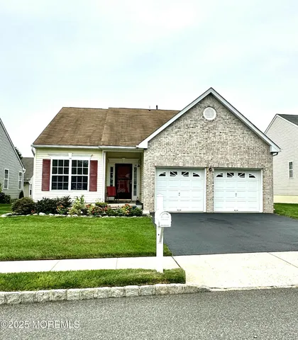 a front view of a house with a garden and yard