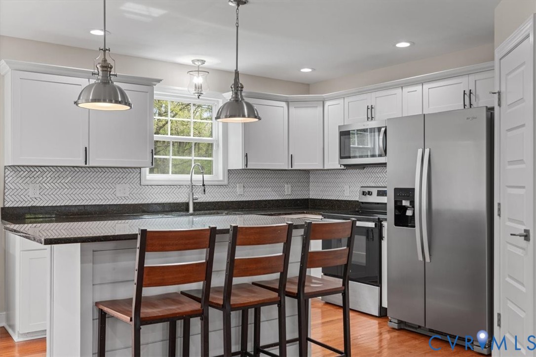 1290 Scotts Court Carson, VA 23830 - Photo 12 of 46 a kitchen with stainless steel appliances granite countertop a stove a microwave a sink and white cabinets