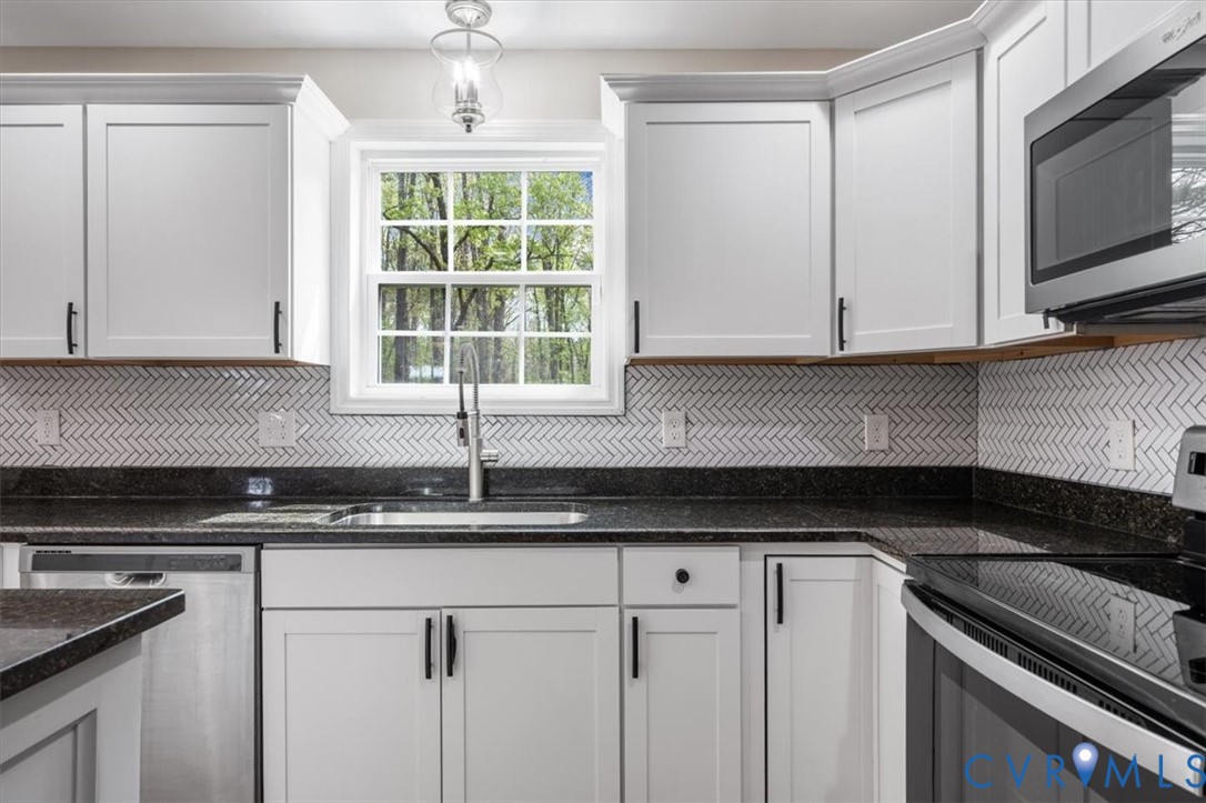 1290 Scotts Court Carson, VA 23830 - Photo 15 of 46 a kitchen with granite countertop white cabinets stainless steel appliances and window