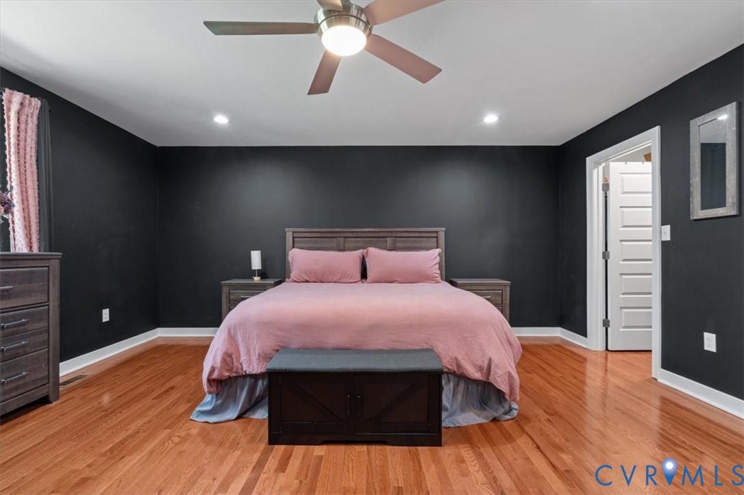 1290 Scotts Court Carson, VA 23830 - Photo 19 of 46 a spacious bedroom with a bed and a flat screen tv