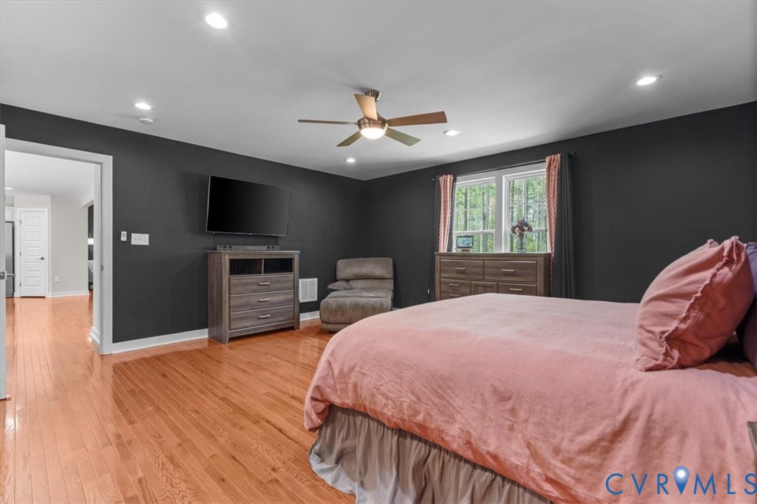 1290 Scotts Court Carson, VA 23830 - Photo 21 of 46 a spacious bedroom with a bed and a flat screen tv