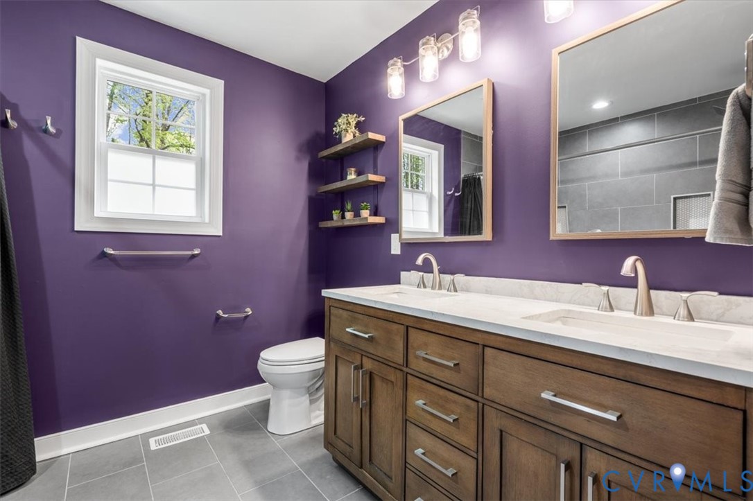 1290 Scotts Court Carson, VA 23830 - Photo 23 of 46 a bathroom with a granite countertop sink a large mirror a toilet and a window