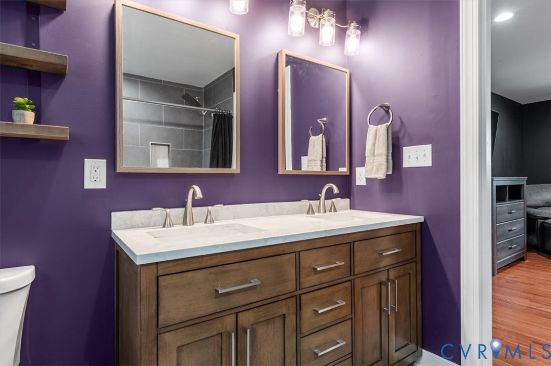1290 Scotts Court Carson, VA 23830 - Photo 26 of 46 a bathroom with a granite countertop sink a large mirror and a toilet
