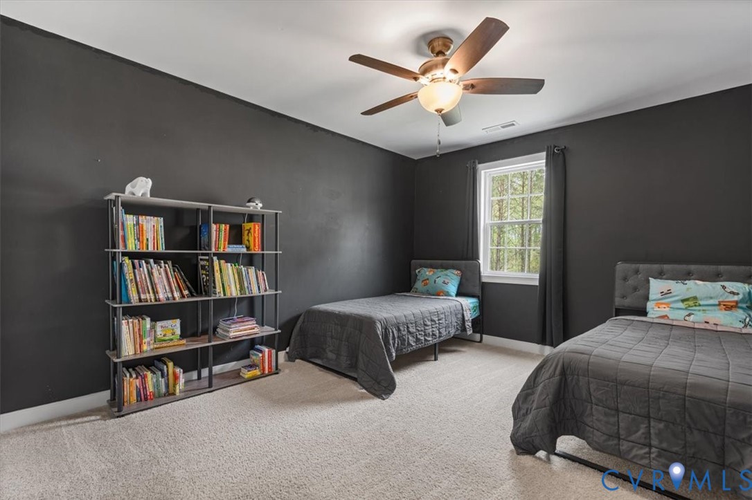 1290 Scotts Court Carson, VA 23830 - Photo 35 of 46 a bedroom with a large bed a book shelf and a window