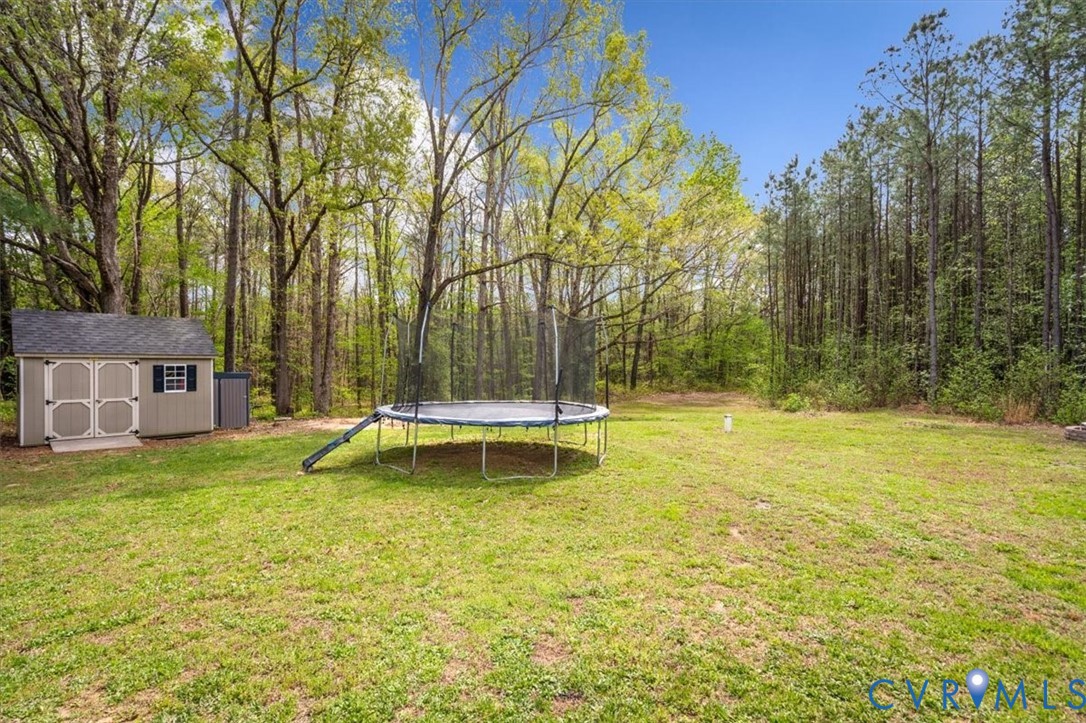 1290 Scotts Court Carson, VA 23830 - Photo 44 of 46 a view of a swimming pool with a bench and trees