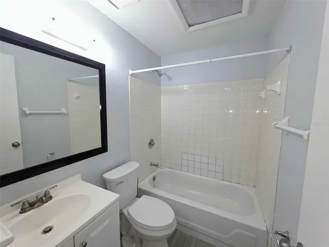 a living room with furniture a flat screen tv and a window