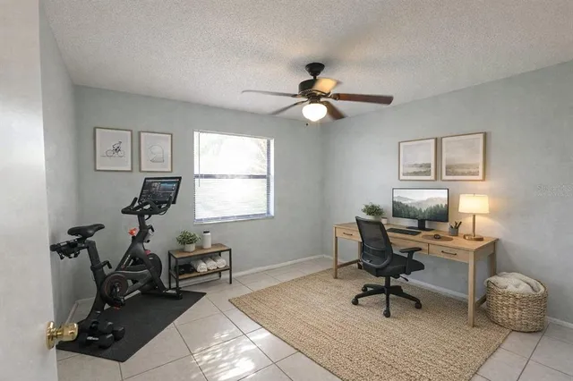 an empty room with windows and fan