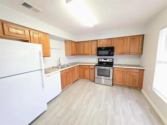 a kitchen with stainless steel appliances a sink a table and chairs