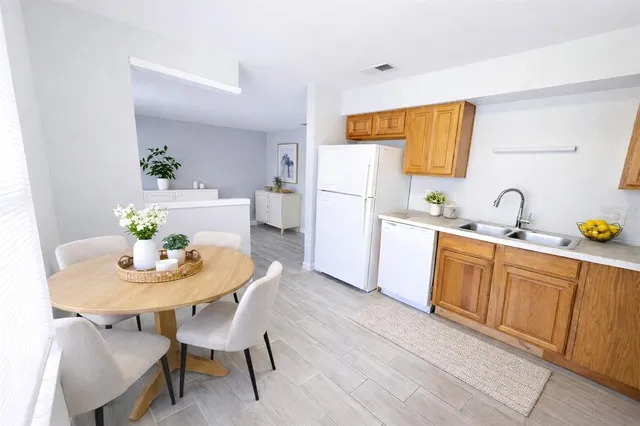 a kitchen with wooden floors and white appliances
