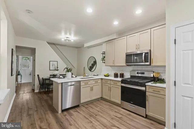 a kitchen with stainless steel appliances a sink stove and cabinets