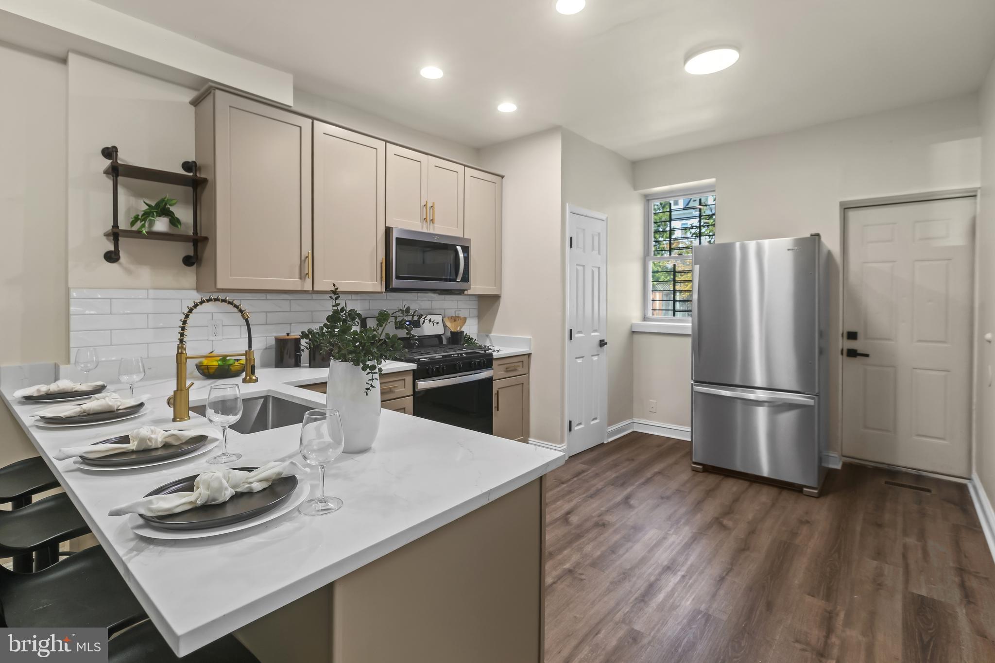 884 Washington Boulevard Baltimore, MD 21230 - Photo 16 of 35 a kitchen with stainless steel appliances a microwave a sink a stove a refrigerator and cabinets