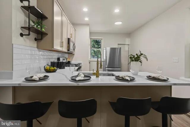 a kitchen with stainless steel appliances a sink and a chair