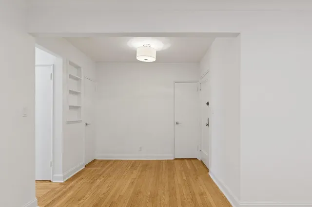 a view of a room with wooden floor and a window