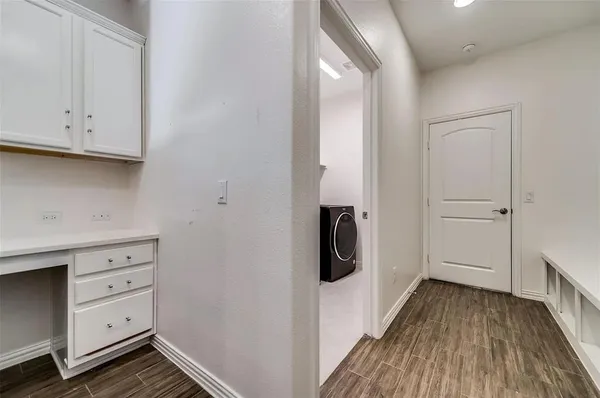 an empty room with wooden floor fireplace and windows