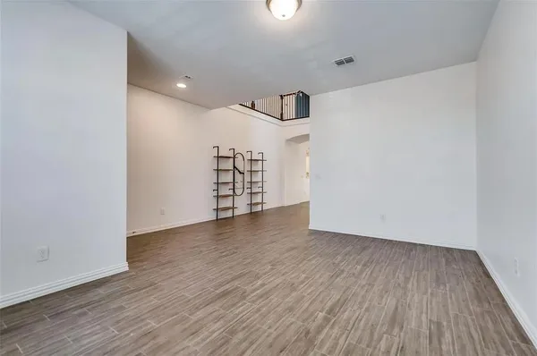 a view of a room with wooden floors and ceiling fan