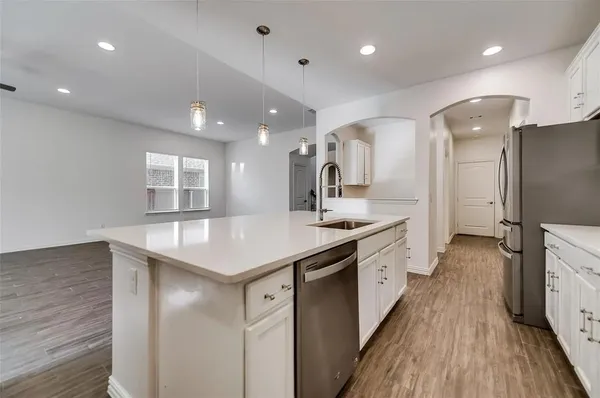 a kitchen with a sink and wooden floor