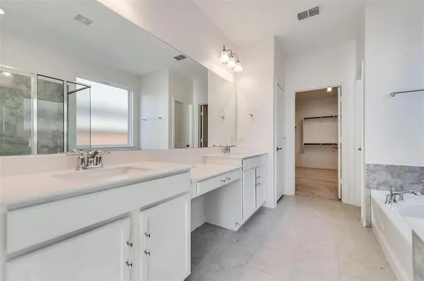 a bathroom with a double vanity sink and a mirror
