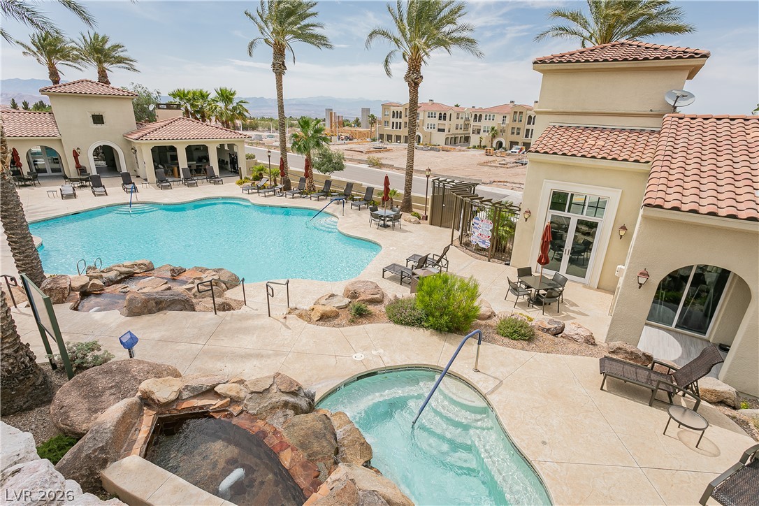 2555 Hampton Road, Unit 3308 Henderson, NV 89052 - Photo 60 of 65 An inviting resort-style pool and hot tub beckon residents with ample lounge seating and palm-lined views.