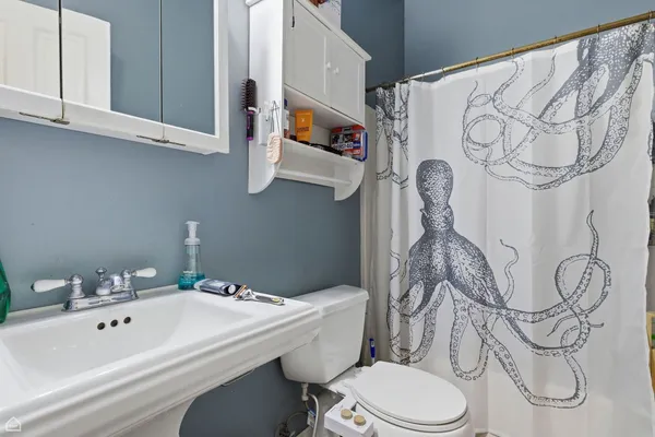 a bathroom with a sink vanity mirror and toilet