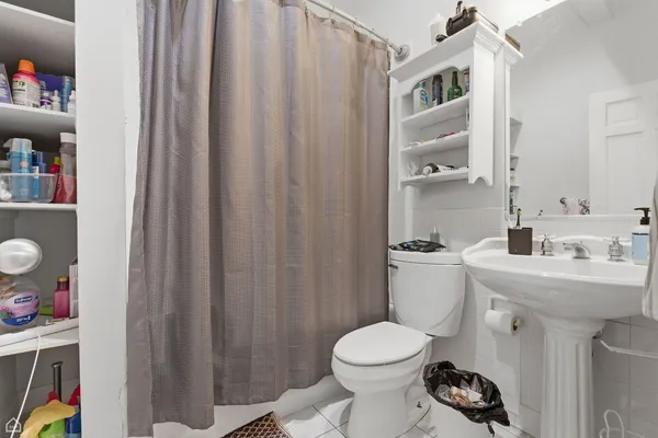 a bathroom with a sink a toilet and shower curtain