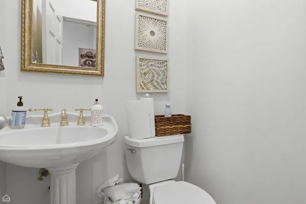 a bathroom with a toilet a sink and mirror