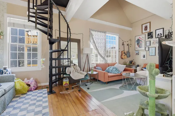 a living room with furniture a flat screen tv and next to a window