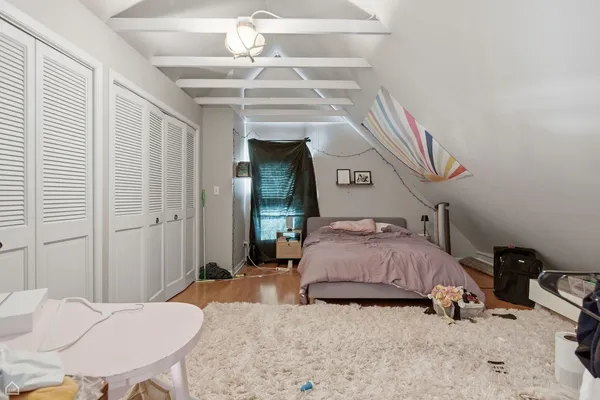 a bedroom with a bed a chandelier and a dresser