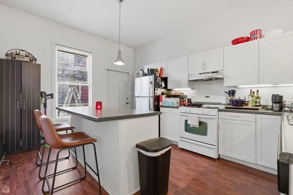 a kitchen with stainless steel appliances granite countertop a stove a sink dishwasher and a refrigerator with wooden floor